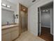 Bathroom with vanity, stone-look shower, and tile floors at 257 Padgett N Pl, Lakeland, FL 33809