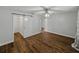 Bedroom with ceiling fan, neutral walls, wood-look flooring, and sliding barn door to closet at 257 Padgett N Pl, Lakeland, FL 33809