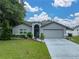 Charming single-story home with a well-manicured lawn and attached two-car garage on a sunny day at 257 Padgett N Pl, Lakeland, FL 33809