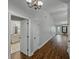 Hallway with hardwood floors, chandelier, leading to bathroom and living area at 257 Padgett N Pl, Lakeland, FL 33809