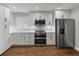 Modern kitchen with stainless steel appliances, white cabinets, white countertop and brick backsplash at 257 Padgett N Pl, Lakeland, FL 33809