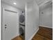 A well-lit laundry area featuring a stackable washer and dryer unit, next to a wall and door at 257 Padgett N Pl, Lakeland, FL 33809