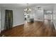 Open-concept living space with hardwood floors, modern lighting, and view of kitchen at 257 Padgett N Pl, Lakeland, FL 33809