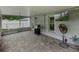 Covered patio with stone floors, grill, and mounted television at 257 Padgett N Pl, Lakeland, FL 33809