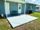 Concrete patio area with a sitting bench, and an exterior door with side windows at 2655 Hempstead Dr, Lakeland, FL 33801