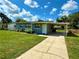 A cozy home with a long driveway, covered carport, and green lawn under a sunny sky at 2655 Hempstead Dr, Lakeland, FL 33801