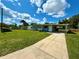 Street view of the house with a long driveway and a green lawn at 2655 Hempstead Dr, Lakeland, FL 33801