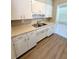 Kitchen featuring white cabinets, updated countertops, modern fixtures, and updated flooring at 2655 Hempstead Dr, Lakeland, FL 33801