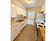 This kitchen features white cabinets and appliances and vinyl floors at 2655 Hempstead Dr, Lakeland, FL 33801