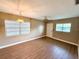 Bright living room with wood-look floors, ceiling fan, and natural light from multiple windows at 2655 Hempstead Dr, Lakeland, FL 33801