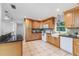 An open kitchen offers wood cabinets, stone countertops, stainless appliances, tile backsplash, and tiled floor at 2726 Cleveland Heights Blvd, Lakeland, FL 33803
