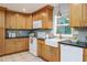 Cozy kitchen with wooden cabinets, black countertop, a white farmhouse sink and tiled backsplash at 2726 Cleveland Heights Blvd, Lakeland, FL 33803