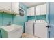 Laundry room with utility sink, washer and dryer, storage cabinets, a window, and tile flooring at 2726 Cleveland Heights Blvd, Lakeland, FL 33803