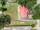 Aerial view of the property with a red roofed house and a large yard with mature trees at 330 Diesel Rd, Mulberry, FL 33860