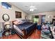 Cozy bedroom with wood-look flooring, a ceiling fan, and a large window offering natural light at 330 Diesel Rd, Mulberry, FL 33860