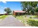 Exterior of the charming home showcasing the long driveway and well-maintained front lawn at 330 Diesel Rd, Mulberry, FL 33860
