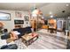 Open-concept living room with wood floors that flows into kitchen featuring stainless steel appliances and wood cabinets at 330 Diesel Rd, Mulberry, FL 33860