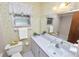 Cozy bathroom features a white vanity, toilet, shower, and vintage floral wallpaper at 3315 Cross Fox Dr, Mulberry, FL 33860