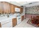 Kitchen with wood cabinets and white appliances, as well as a dining area table and chairs at 3315 Cross Fox Dr, Mulberry, FL 33860
