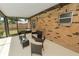 Comfortable outdoor seating area on the screened-in patio with brick detail at 3315 Cross Fox Dr, Mulberry, FL 33860
