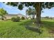 Serene backyard featuring a mature tree, garden bench, and lush lawn at 3370 Highland Fairways Blvd, Lakeland, FL 33810