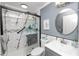 Modern bathroom featuring marble shower with glass door, updated vanity, and round mirror at 3370 Highland Fairways Blvd, Lakeland, FL 33810