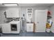Functional laundry room with modern washer and dryer, utility sink, and ample storage cabinets at 3370 Highland Fairways Blvd, Lakeland, FL 33810