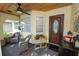 Cozy screened porch with comfortable seating, a ceiling fan, and an inviting front entrance at 3370 Highland Fairways Blvd, Lakeland, FL 33810