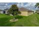 Exterior shot of the backyard with the lush green lawn and a mature tree at 3427 Waterlute Way, Lakeland, FL 33811