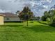 An expansive green backyard features lush lawn, a tree and is perfect for outdoor activities and relaxation at 3427 Waterlute Way, Lakeland, FL 33811