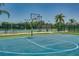 Outdoor basketball court surrounded by trees with tennis courts in the background at 3427 Waterlute Way, Lakeland, FL 33811