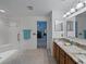 Large bathroom featuring a tiled shower and a double granite countertop vanity at 3427 Waterlute Way, Lakeland, FL 33811