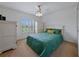Well-lit bedroom with a queen bed, ceiling fan, and plantation shutters at 3427 Waterlute Way, Lakeland, FL 33811