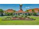 Beautiful community clubhouse with manicured landscaping, lush gardens, and palm trees creating a welcoming atmosphere at 3427 Waterlute Way, Lakeland, FL 33811