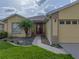 Charming home featuring a red front door, lush lawn, and well-manicured landscaping at 3427 Waterlute Way, Lakeland, FL 33811