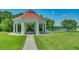 Picturesque gazebo with red roof and picnic tables overlooking the lake and lawn at 3427 Waterlute Way, Lakeland, FL 33811