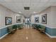 Inviting hallway featuring wood-look floors, framed art, and comfortable seating areas with decorative plants at 3427 Waterlute Way, Lakeland, FL 33811