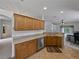 Spacious kitchen with stainless steel appliances, wooden cabinetry, and breakfast bar open to living room at 3427 Waterlute Way, Lakeland, FL 33811
