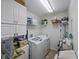Well-lit laundry room with storage cabinets, shelves, a washer, and a dryer at 3427 Waterlute Way, Lakeland, FL 33811