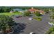 View of clubhouse and the parking lot, lush landscaping and mature trees at 3427 Waterlute Way, Lakeland, FL 33811