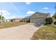 View of house with wide driveway, neutral paint, well-maintained landscaping, and an attached garage at 367 Cloverdale Rd, Winter Haven, FL 33884