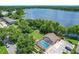 Aerial view of a screened in swimming pool with a lake in the background at 3806 Osprey Pointe Cir, Winter Haven, FL 33884