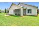 Back of the house with a screened patio and grassy lawn at 3806 Osprey Pointe Cir, Winter Haven, FL 33884