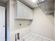 Practical laundry room features storage cabinets and convenient hookups for appliances at 3806 Osprey Pointe Cir, Winter Haven, FL 33884