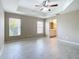 Bright primary bedroom with a ceiling fan, tray ceiling and a view to the bathroom at 3806 Osprey Pointe Cir, Winter Haven, FL 33884