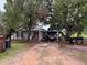 Charming white brick home featuring an open carport and mature trees at 4011 E Robinson Dr, Haines City, FL 33844