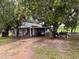 Charming white brick home featuring an open carport and mature trees at 4011 E Robinson Dr, Haines City, FL 33844