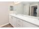 Bathroom showcasing double sinks, white cabinetry, laminate countertops, and a large mirror at 408 Ituna Cir, Winter Haven, FL 33881