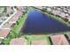 Community aerial view shows a large pond surrounded by houses and lush landscaping at 4188 Muirfield Loop, Lake Wales, FL 33859