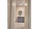 Bathroom with tile floor, vanity with gray cabinets and round mirror at 4188 Muirfield Loop, Lake Wales, FL 33859